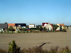 Feld, dahinter Ansiedlung